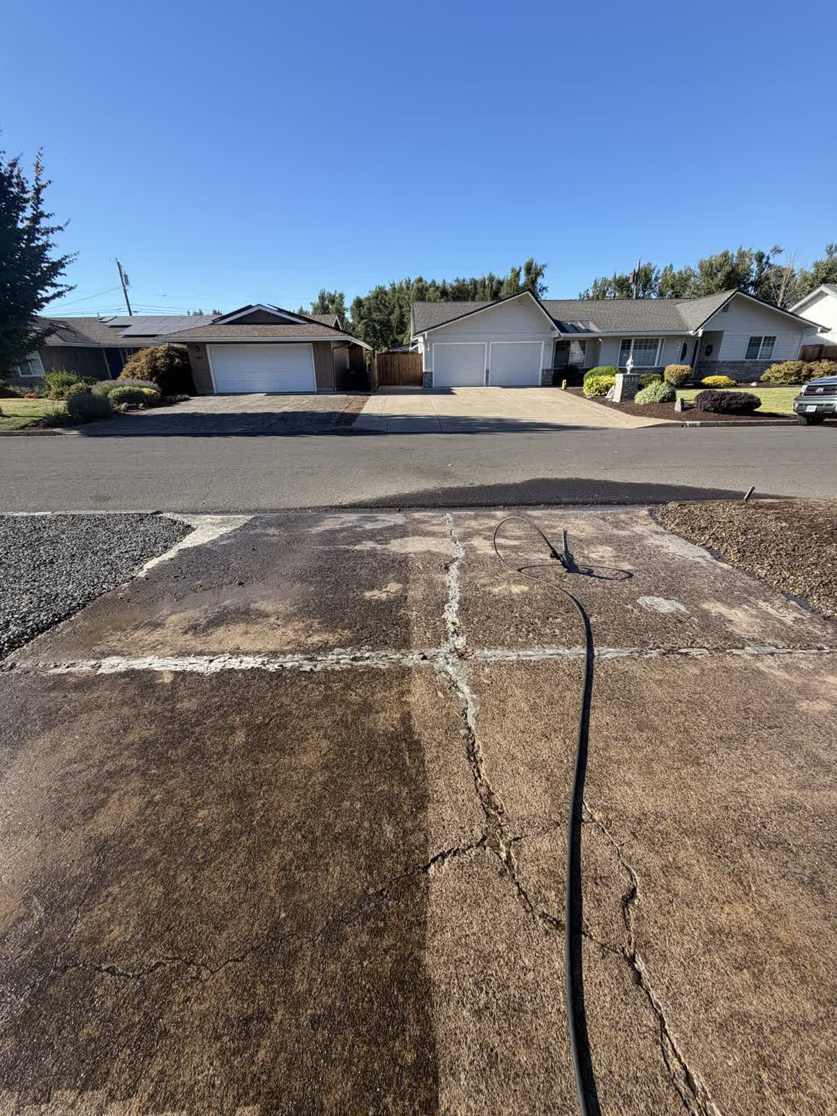 D&T Exterior Services LLC pressure washing a concrete walkway with a surface cleaner in Eugene, Oregon
