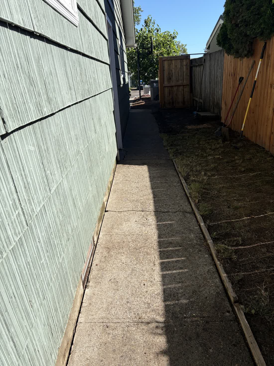 Narrow side path between a house and a fence, washed and cleared by D&T Exterior Services LLC