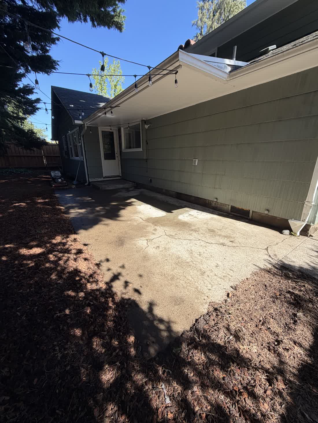 Concrete pad and side yard cleared alongside a house in the Eugene, Oregon area