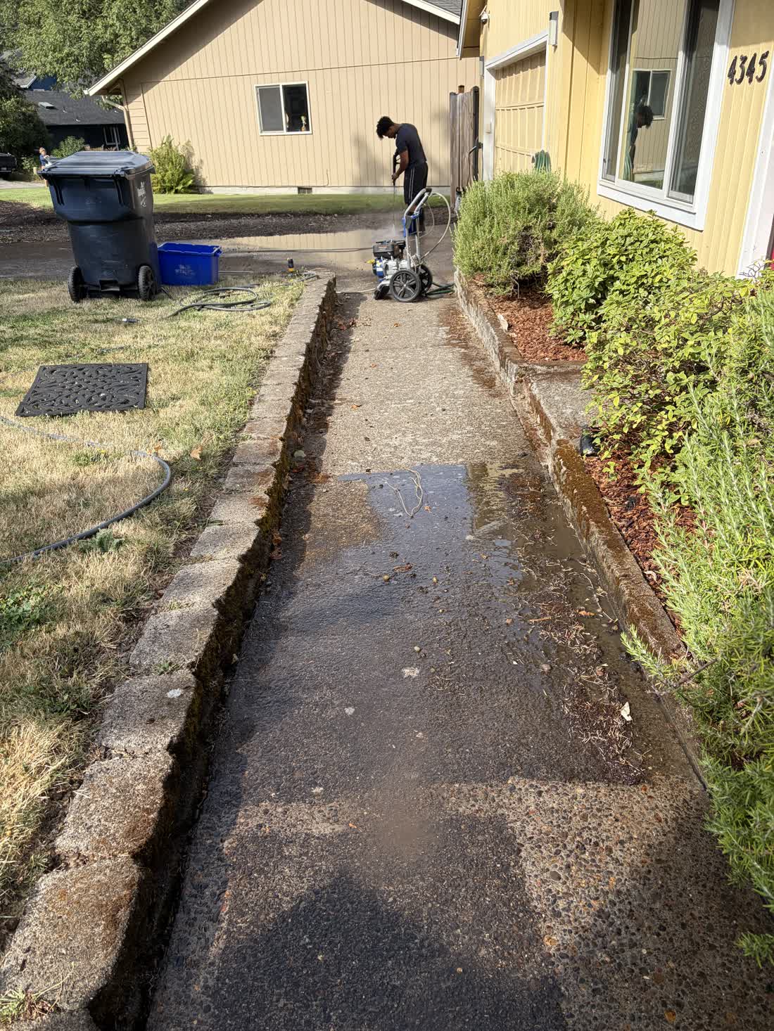 D&T Exterior Services LLC running a surface cleaner along a concrete walkway in Eugene, Oregon